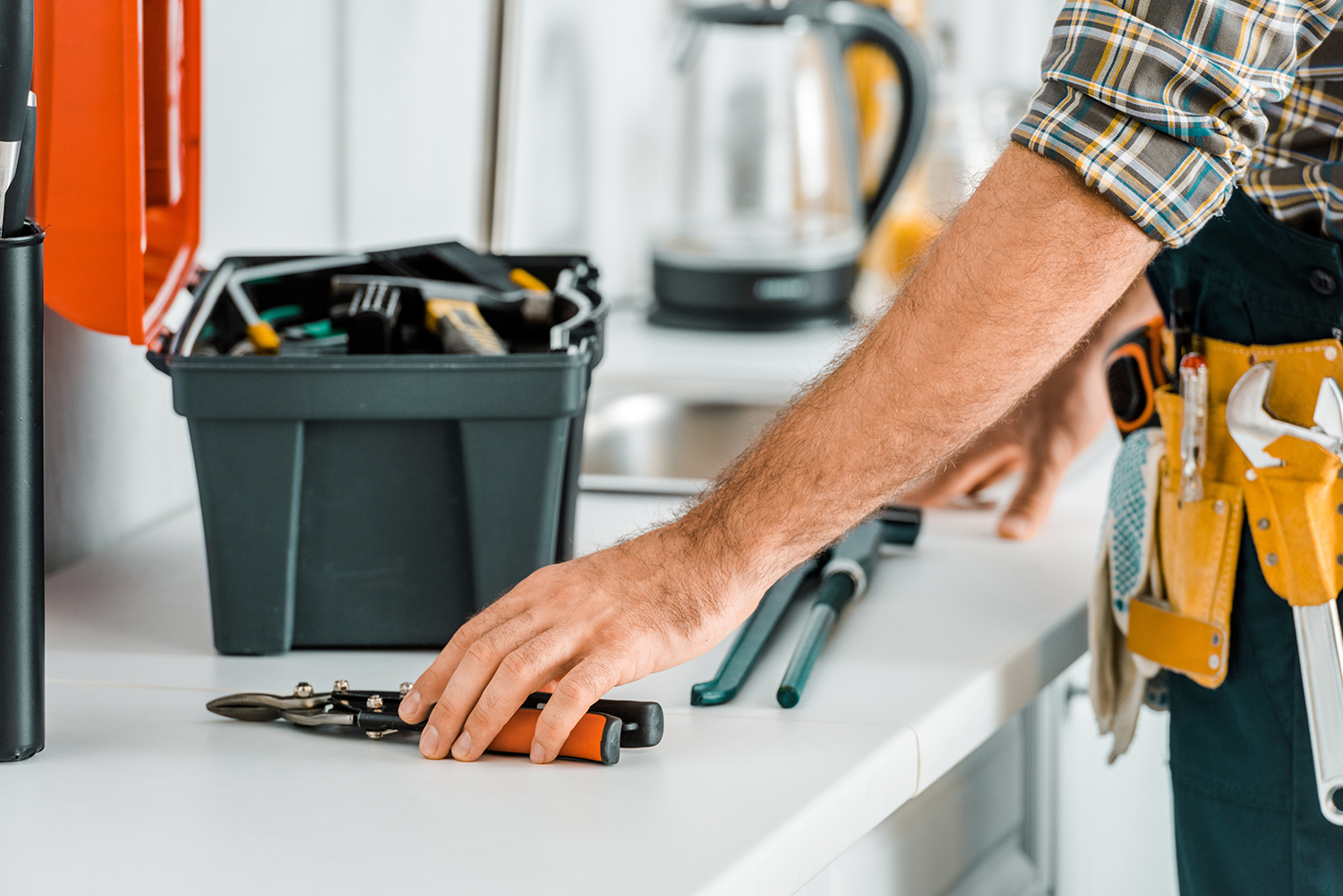hotel maintenance technician with tool box on kitchenette counter
