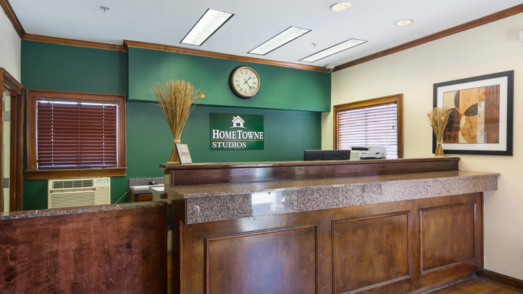 Interior of a HomeTowne Studios and Suites lobby ready for a front desk clerk