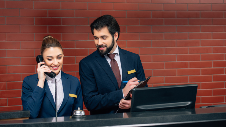happy young hotel receptionists at workplace