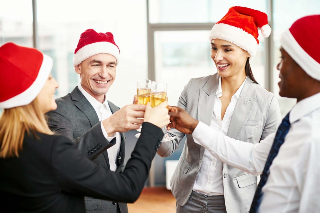 four work colleagues cheering one another during a party for the holidays