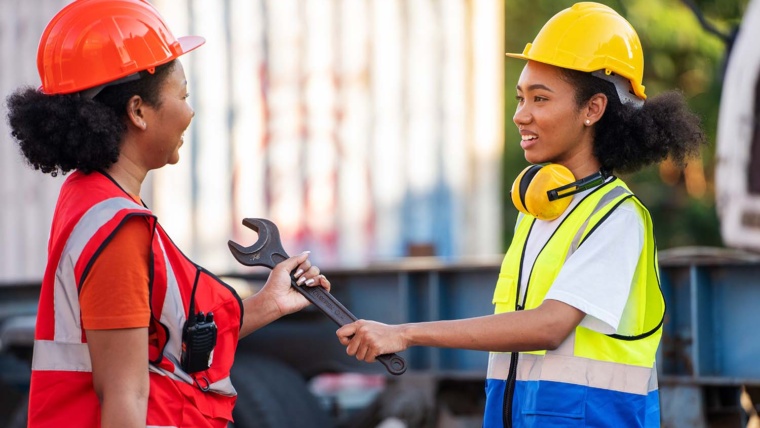 Two female maitenance technicians exchanging tools at an extended stay hotel maintenance shop