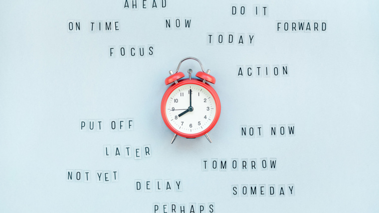 Clock on blue background as a concept of procrastination and time management